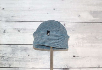 Toddler Acrylic Cuff Hat – Soft Knit Beanie displayed on a stand against a wood background.