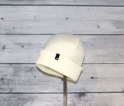 Toddler Acrylic Cuff Hat – Soft Knit Beanie displayed on a stand against a wooden background.