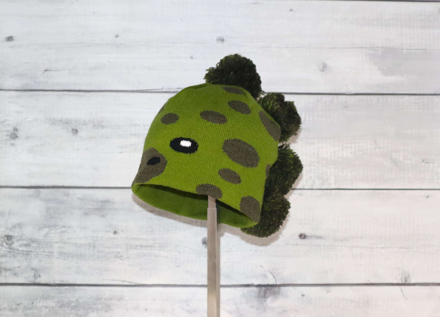 Toddler Specialty Hat – Animal-Inspired Warmth with Purpose featuring a green dinosaur design on a cozy hat.