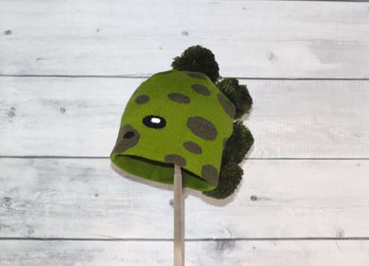 Toddler Specialty Hat – Animal-Inspired Warmth with Purpose featuring a green dinosaur design on a cozy hat.