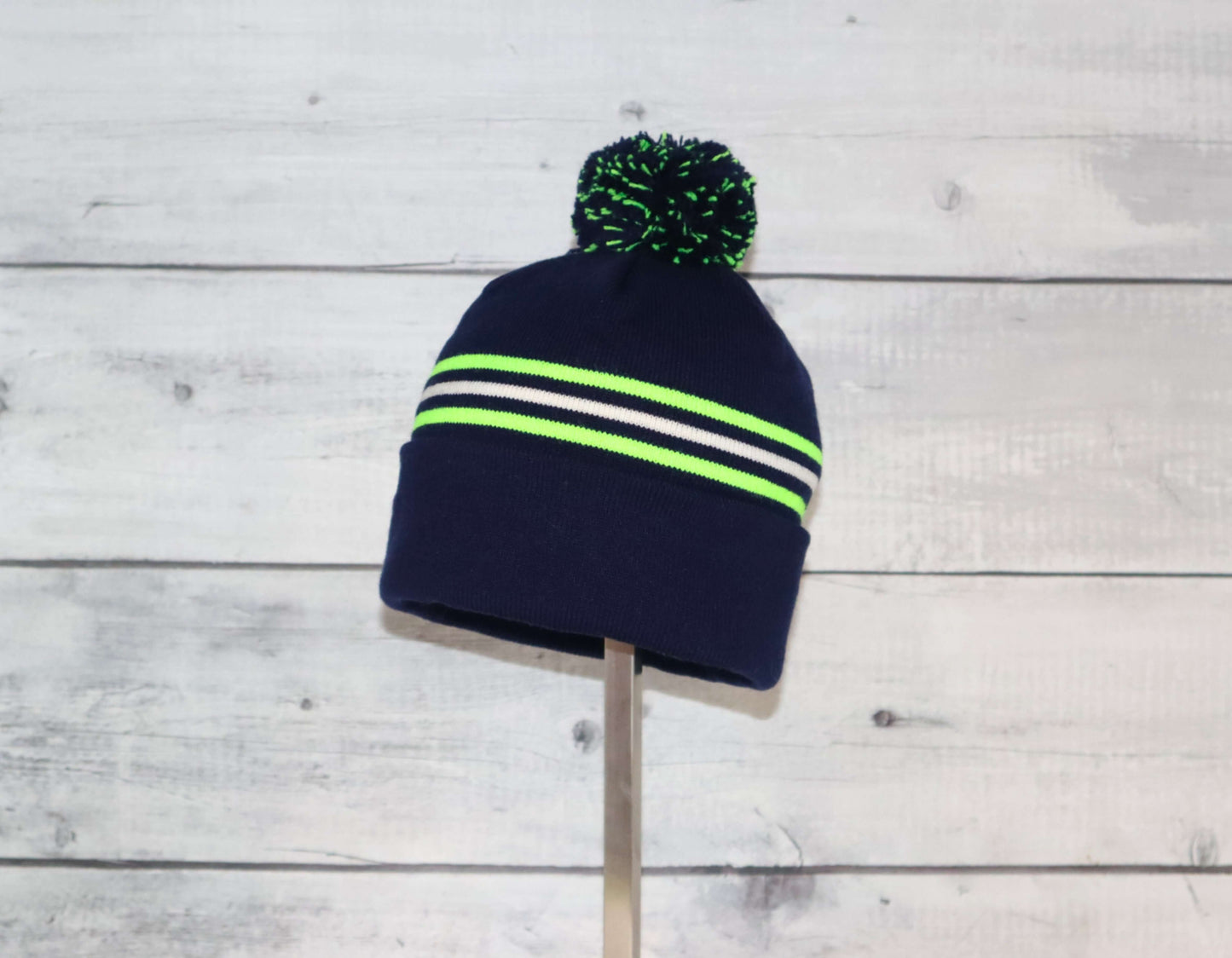 Toddler Specialty Hat – Animal-Inspired Warmth with Purpose in navy with neon stripes and pom-pom on top.