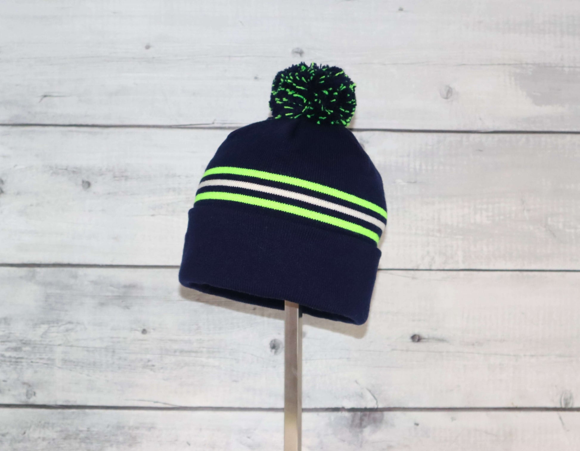 Toddler Specialty Hat – Animal-Inspired Warmth with Purpose in navy with neon stripes and pom-pom on top.