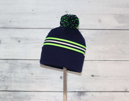 Toddler Specialty Hat – Animal-Inspired Warmth with Purpose in navy with neon stripes and pom-pom on top.