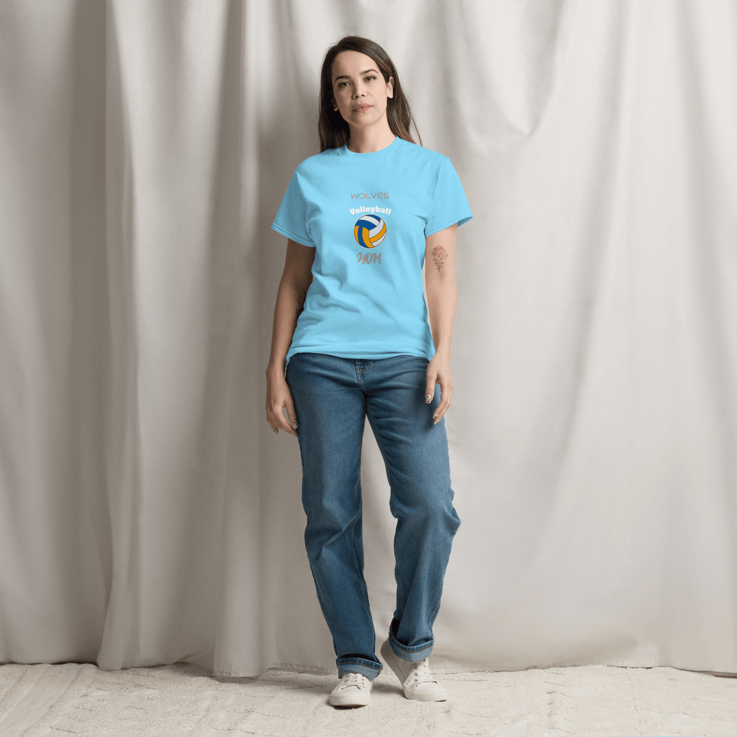 Woman wearing a blue custom volleyball parent tee with 'Wolves Volleyball Mom' design, perfect for game day.