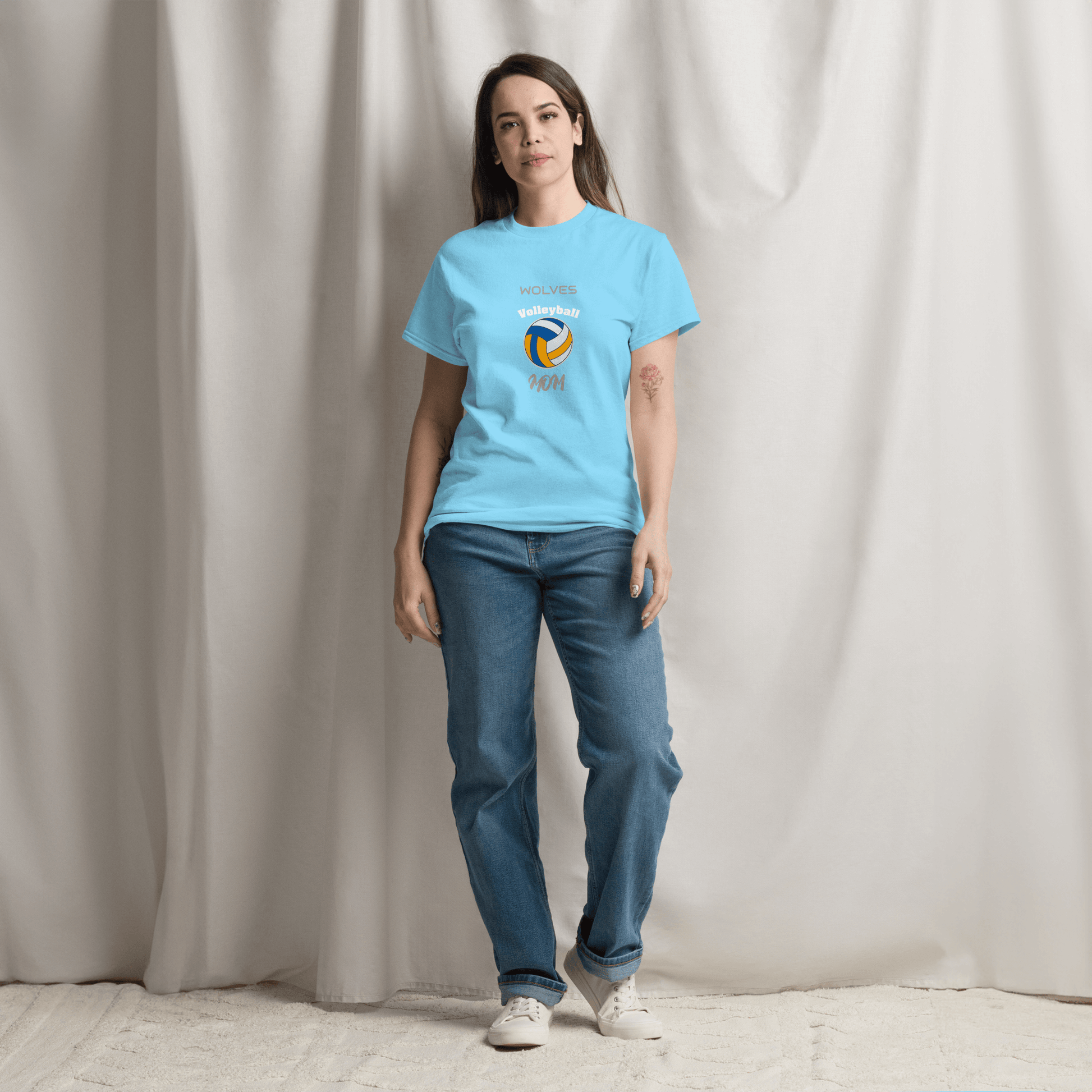 Woman wearing a blue custom volleyball parent tee with 'Wolves Volleyball Mom' design, perfect for game day.
