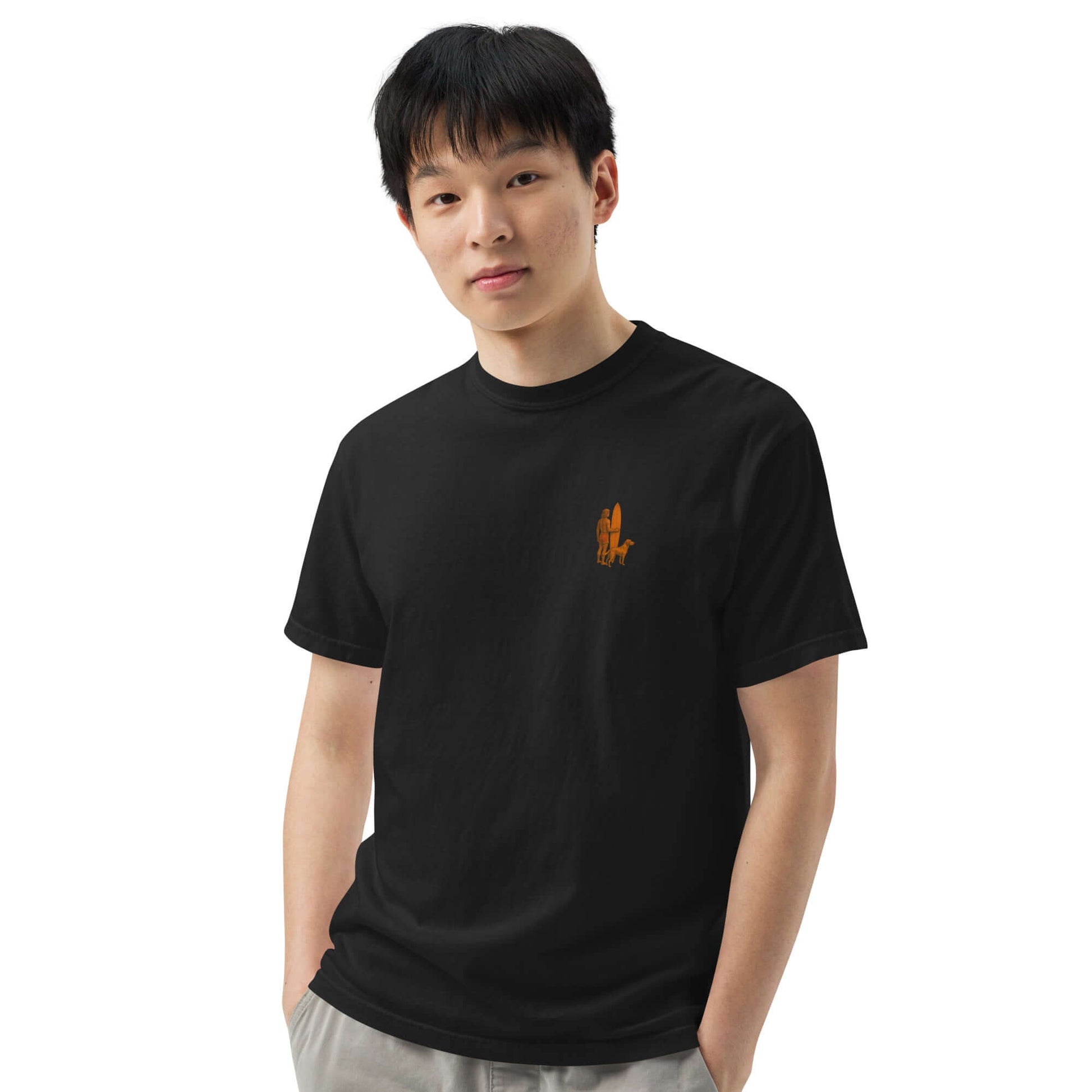 Young man wearing a black Surf Sunset Heavyweight Tee with a minimalist surfer and dog design.