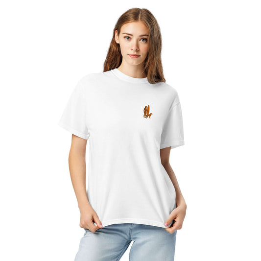 Model wearing a white heavyweight tee featuring a minimalist surfer-and-dog silhouette design.