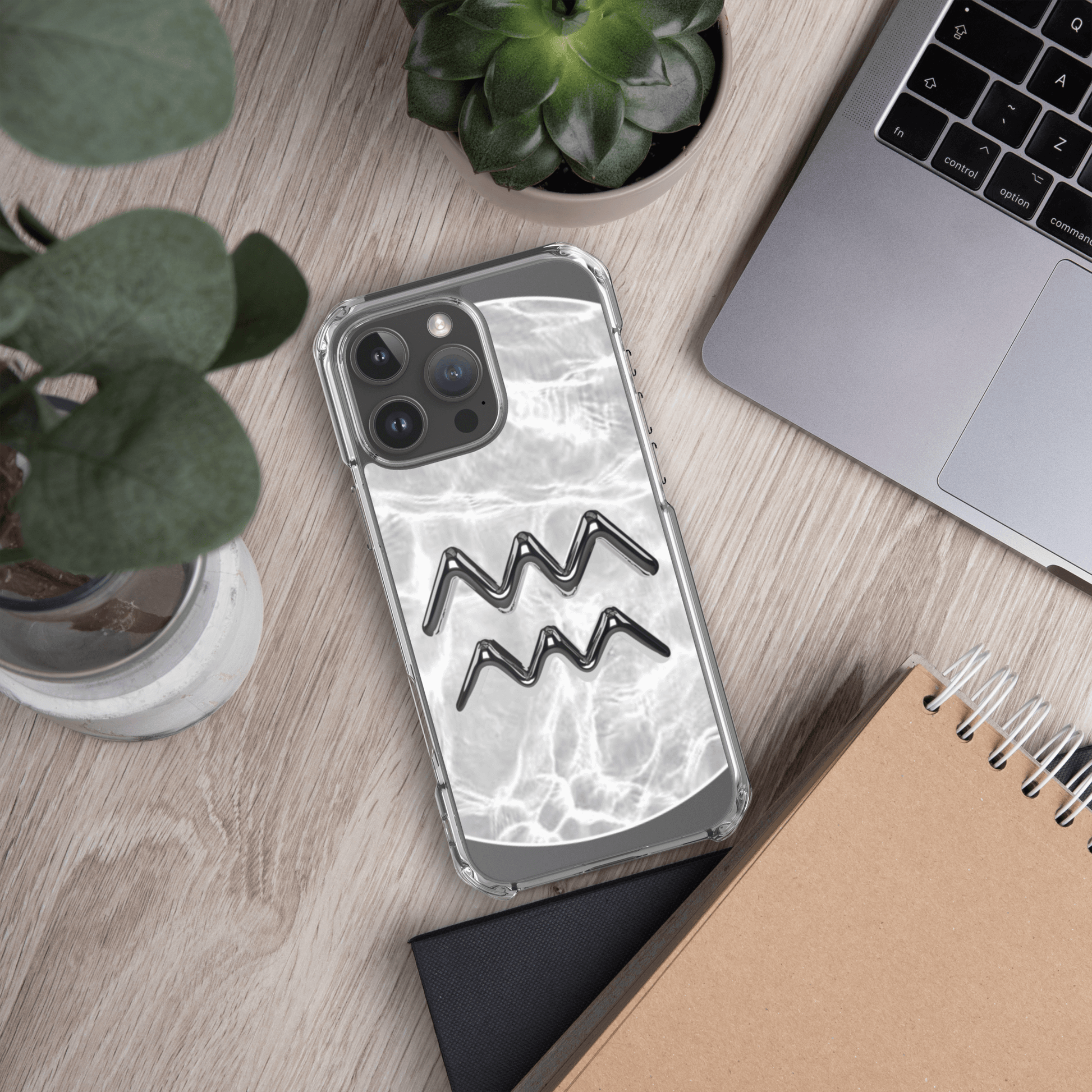 Zodiac Aquarius Magsafe clear iPhone case with marble metallic design on desk with plants and laptop.