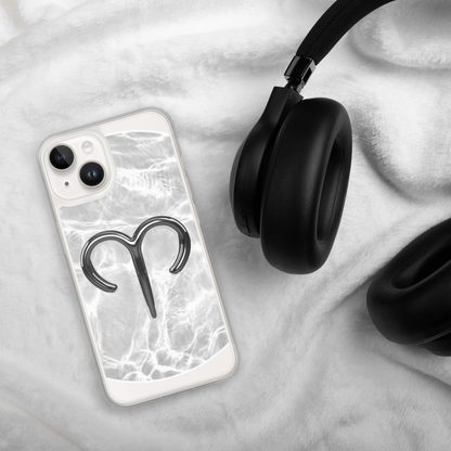 Zodiac Aries MagSafe clear iPhone case with metallic design on a cozy fabric, next to stylish headphones.