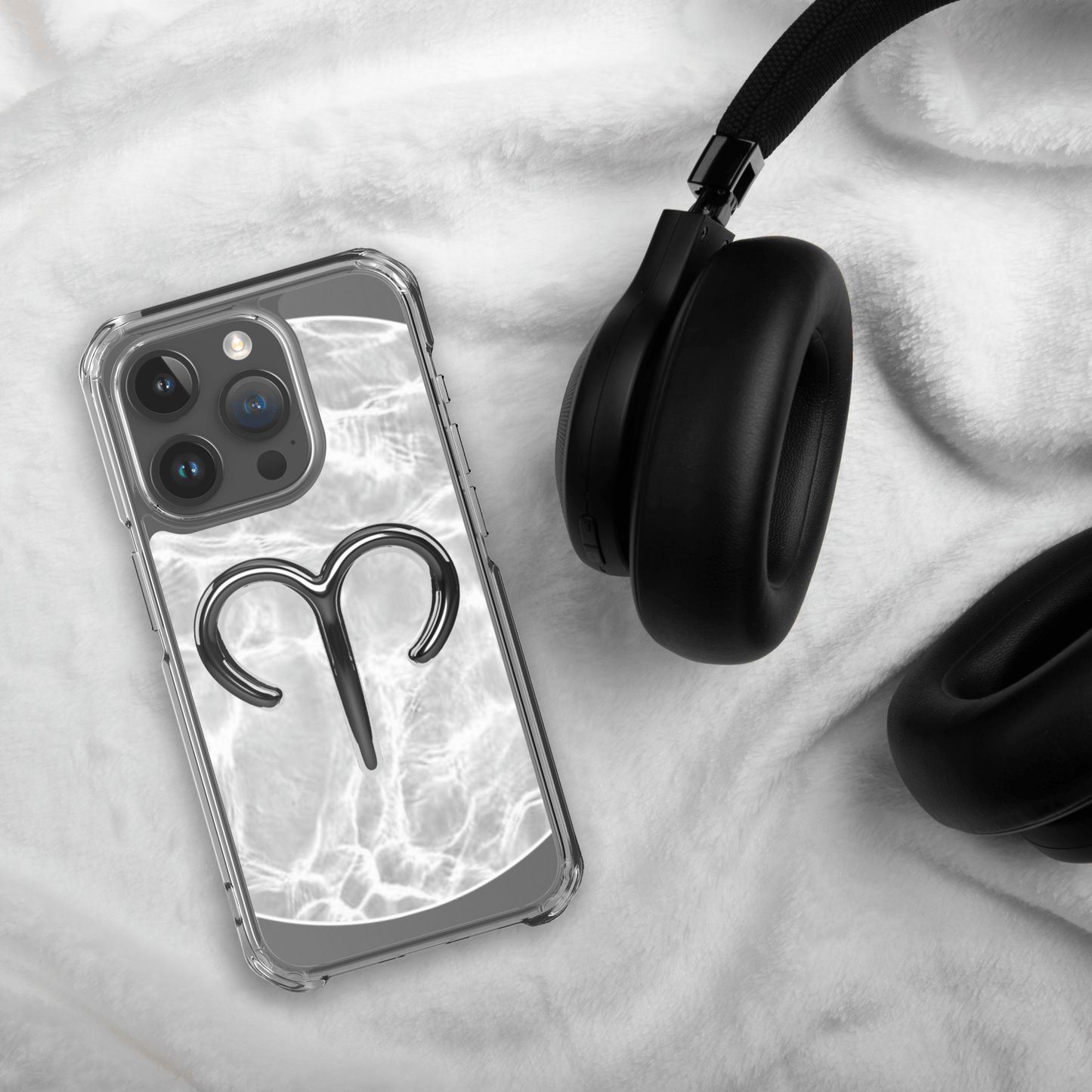 Zodiac Aries MagSafe clear iPhone case on a cozy surface with headphones, showcasing a marble metallic design.