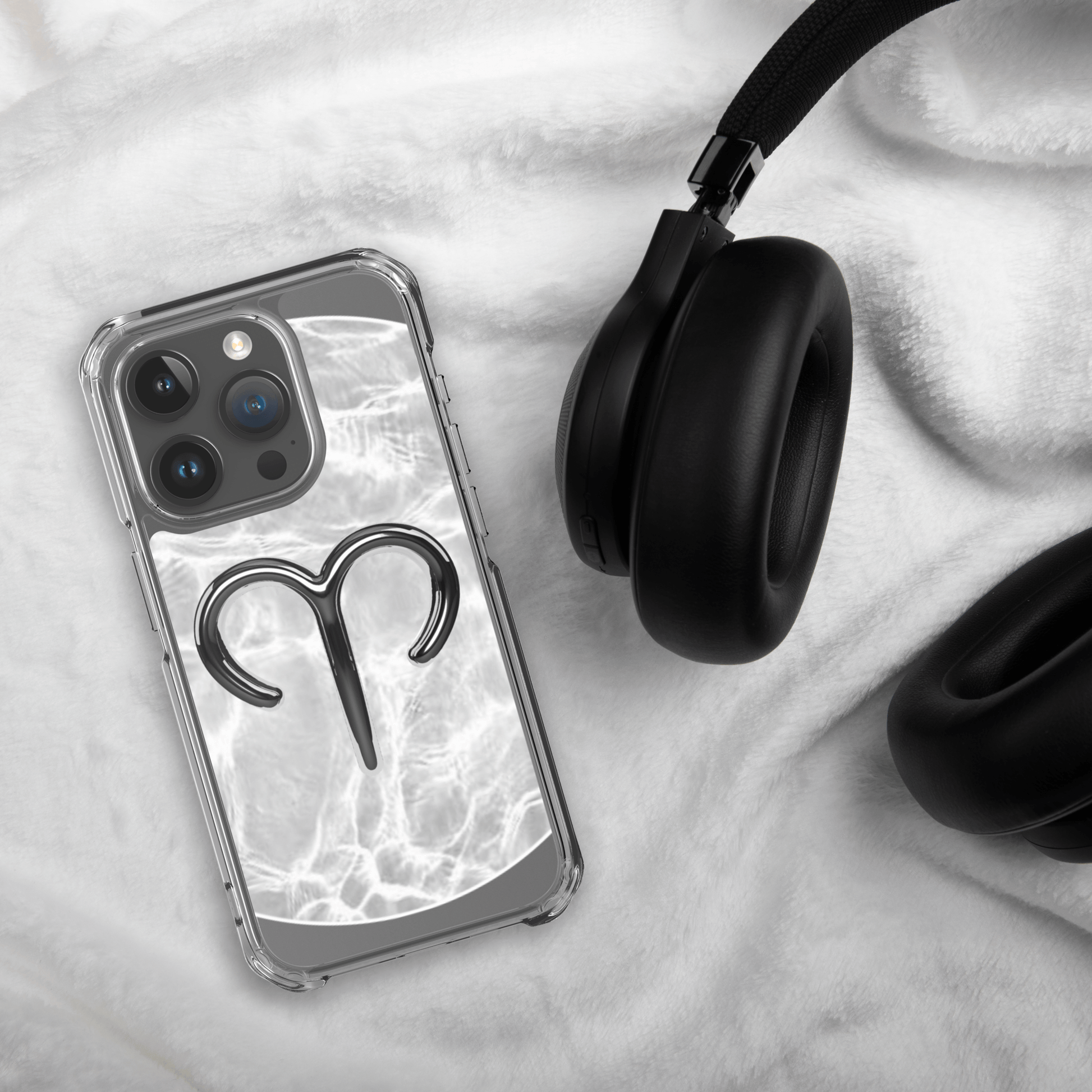 Zodiac Aries MagSafe clear iPhone case on a cozy surface with headphones, showcasing a marble metallic design.