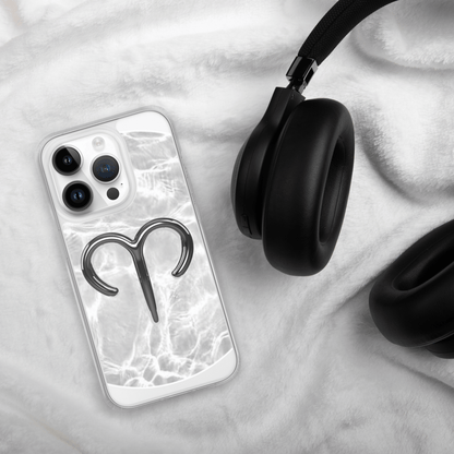 Zodiac Aries MagSafe clear iPhone case with marble design next to black headphones on soft white blanket.