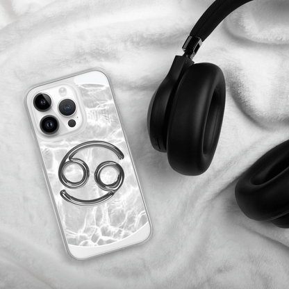 Zodiac Cancer Magsafe Clear iPhone Case with metallic design on cozy background next to headphones.