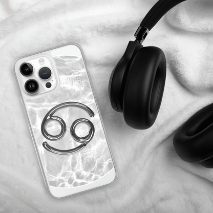 Zodiac Cancer Metallic design clear iPhone case atop soft grey fabric near black headphones.