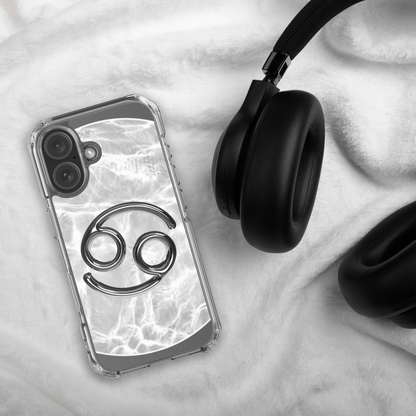 Zodiac Cancer Magsafe Clear iPhone Case with metallic design on marble background next to headphones.