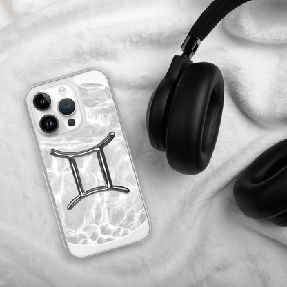 Gemini Magsafe clear iPhone case with marble design next to black headphones on soft fabric.