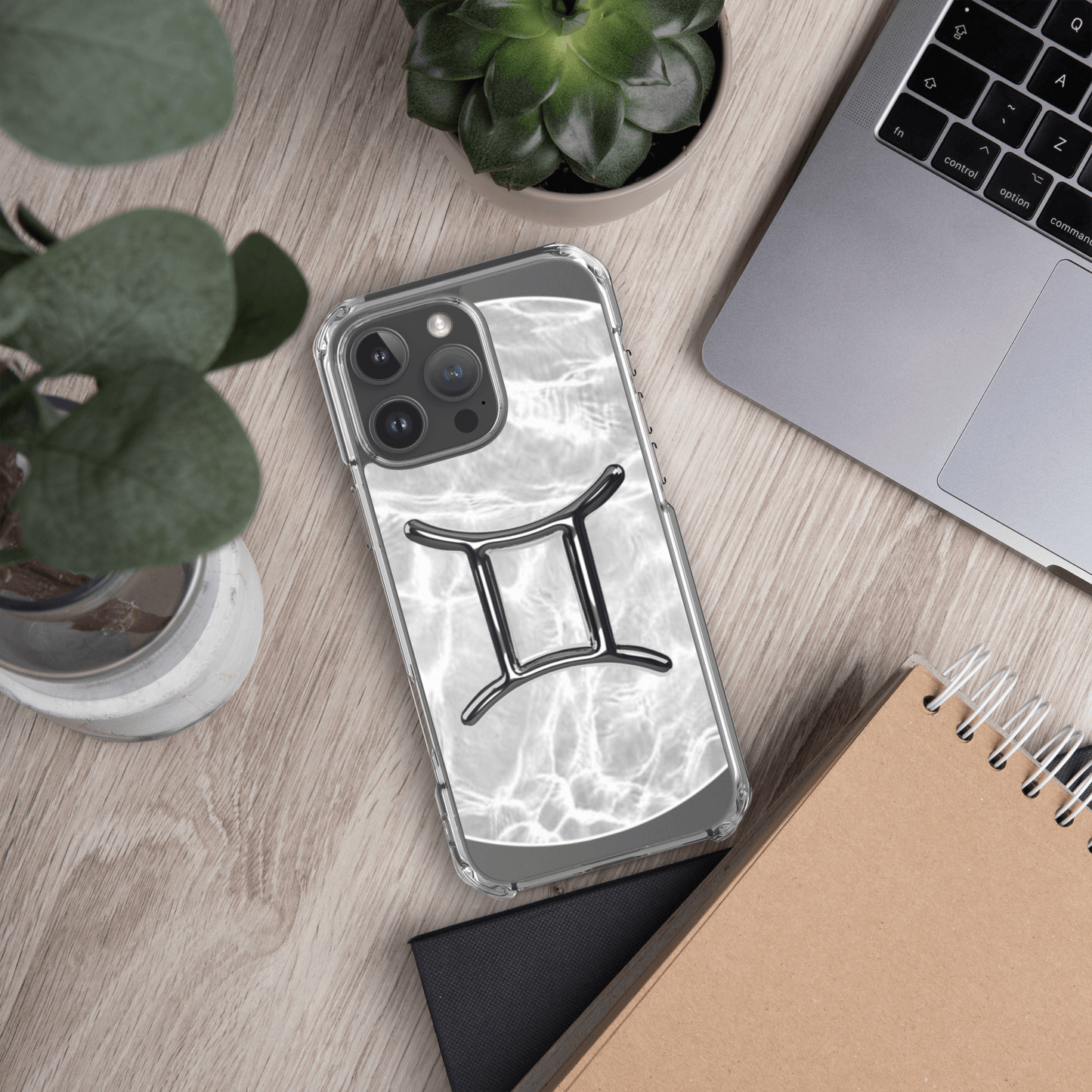 Zodiac Gemini MagSafe clear iPhone case with marble design, stylishly placed on a wooden desk.