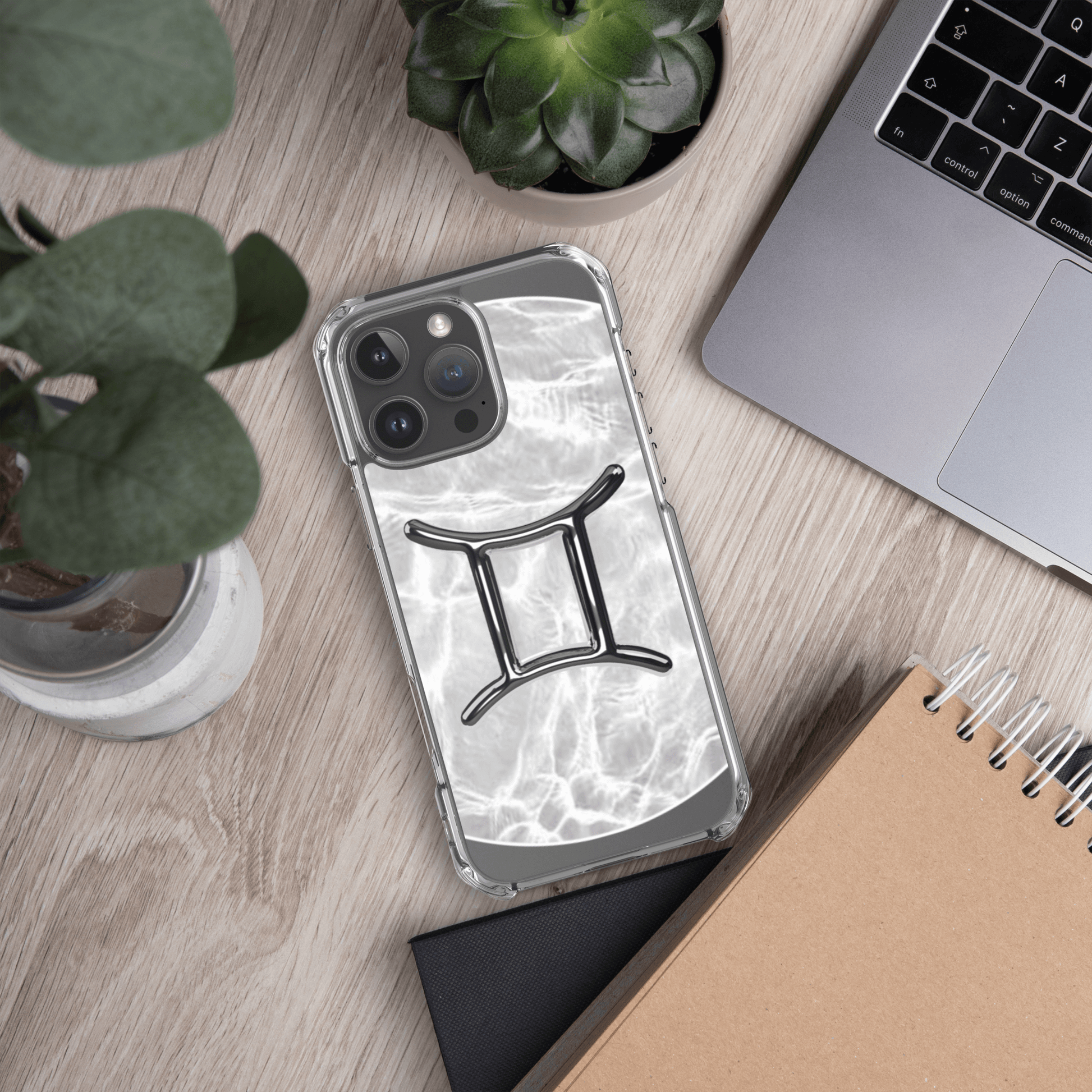 Zodiac Gemini MagSafe clear iPhone case with marble design, stylishly placed on a wooden desk.