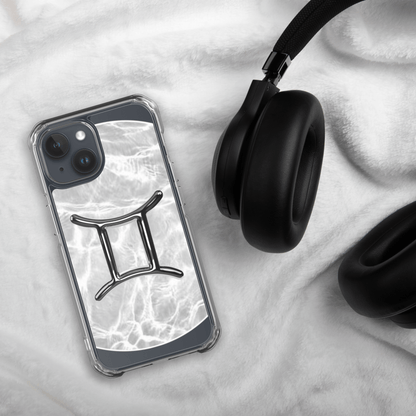 Zodiac Gemini Magsafe Clear iPhone Case with marble design beside black headphones on soft surface.