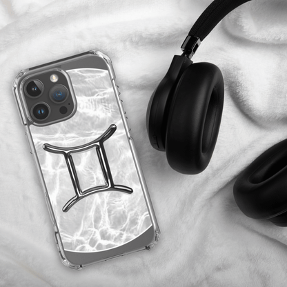 Zodiac Gemini Magsafe clear iPhone case with marble design and headphone on white fabric background.