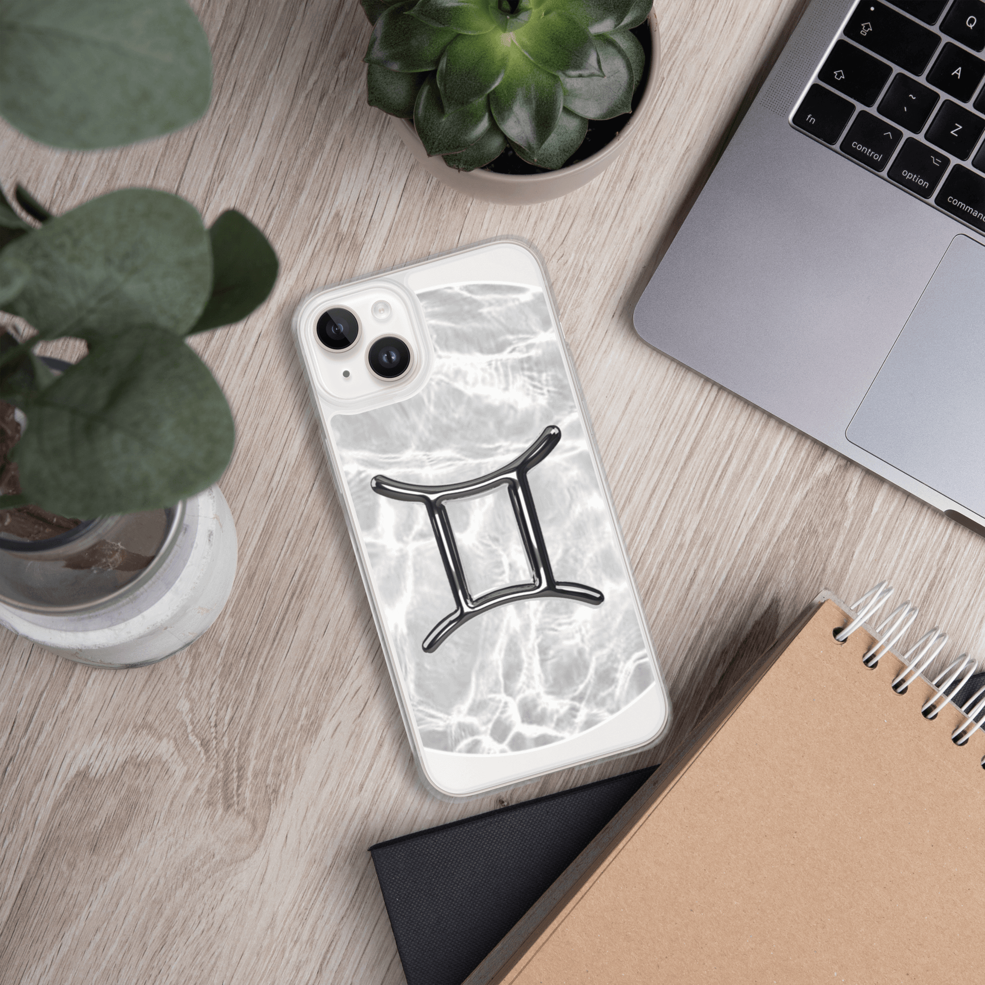 Gemini Magsafe clear iPhone case with marble design on a desk, surrounded by plants and a laptop.