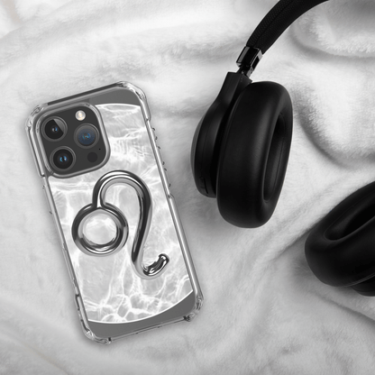 Zodiac Leo Magsafe clear iPhone case with metallic design on soft blanket next to black headphones.