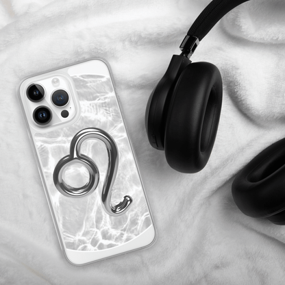Zodiac Leo Magsafe iPhone case with metallic design on a soft white surface next to black headphones.