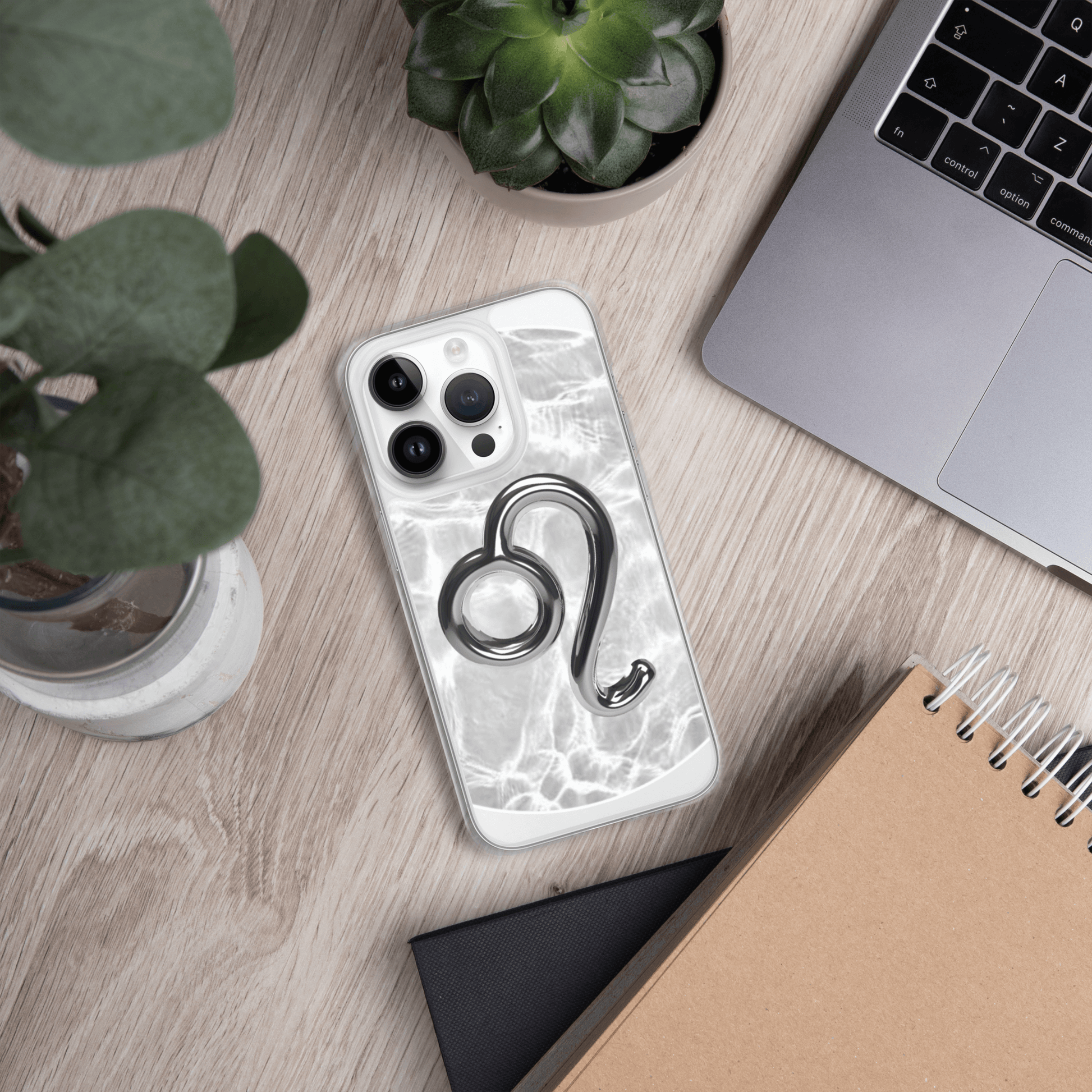 Zodiac Leo Magsafe clear iPhone case with metallic design on marble background, placed on a wooden desk.