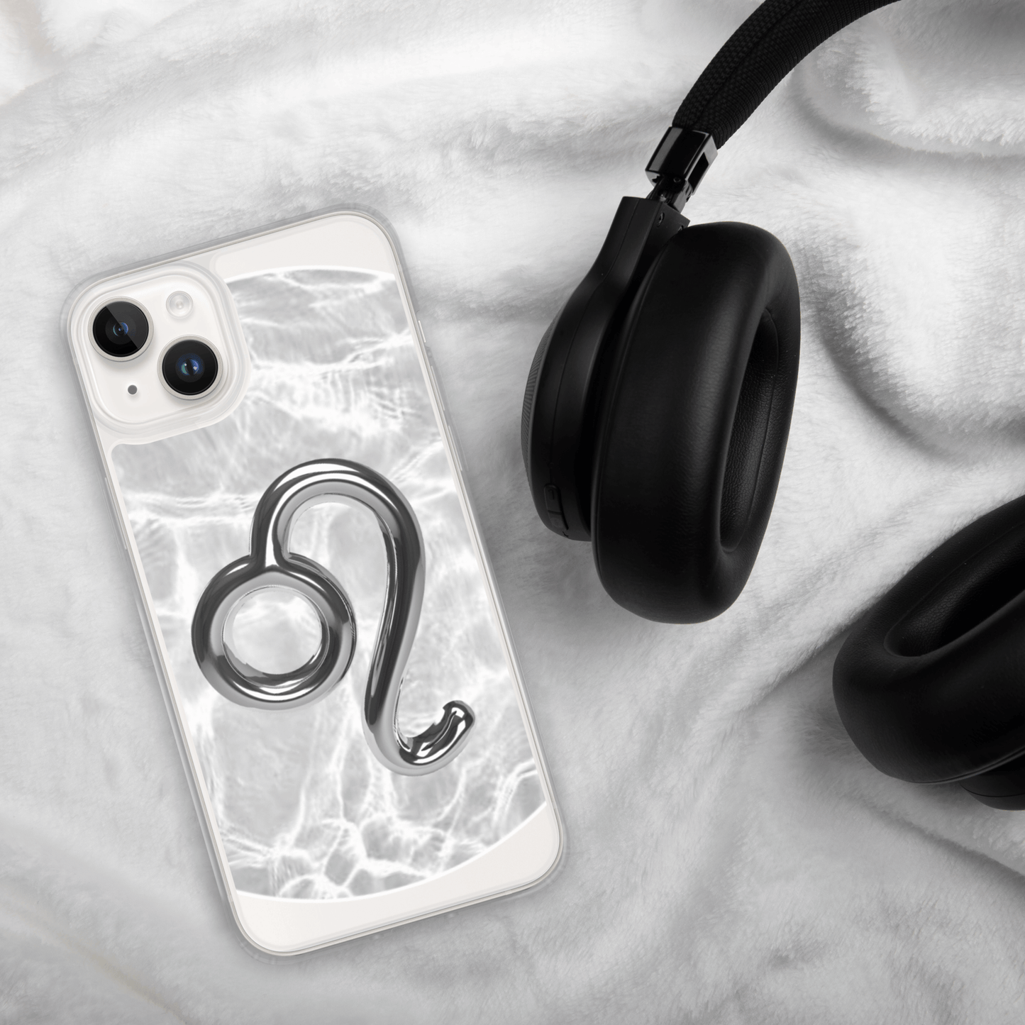 Zodiac Leo Magsafe clear iPhone case with metallic design on a soft background with headphones.