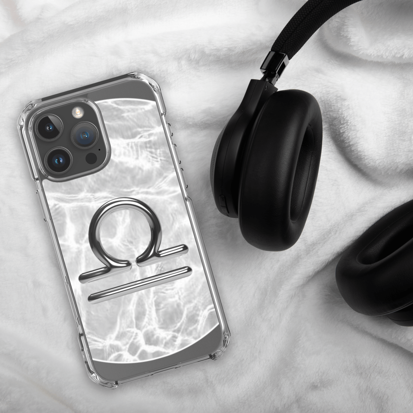 Libra zodiac Magsafe clear iPhone case with marble design next to headphones on soft background.