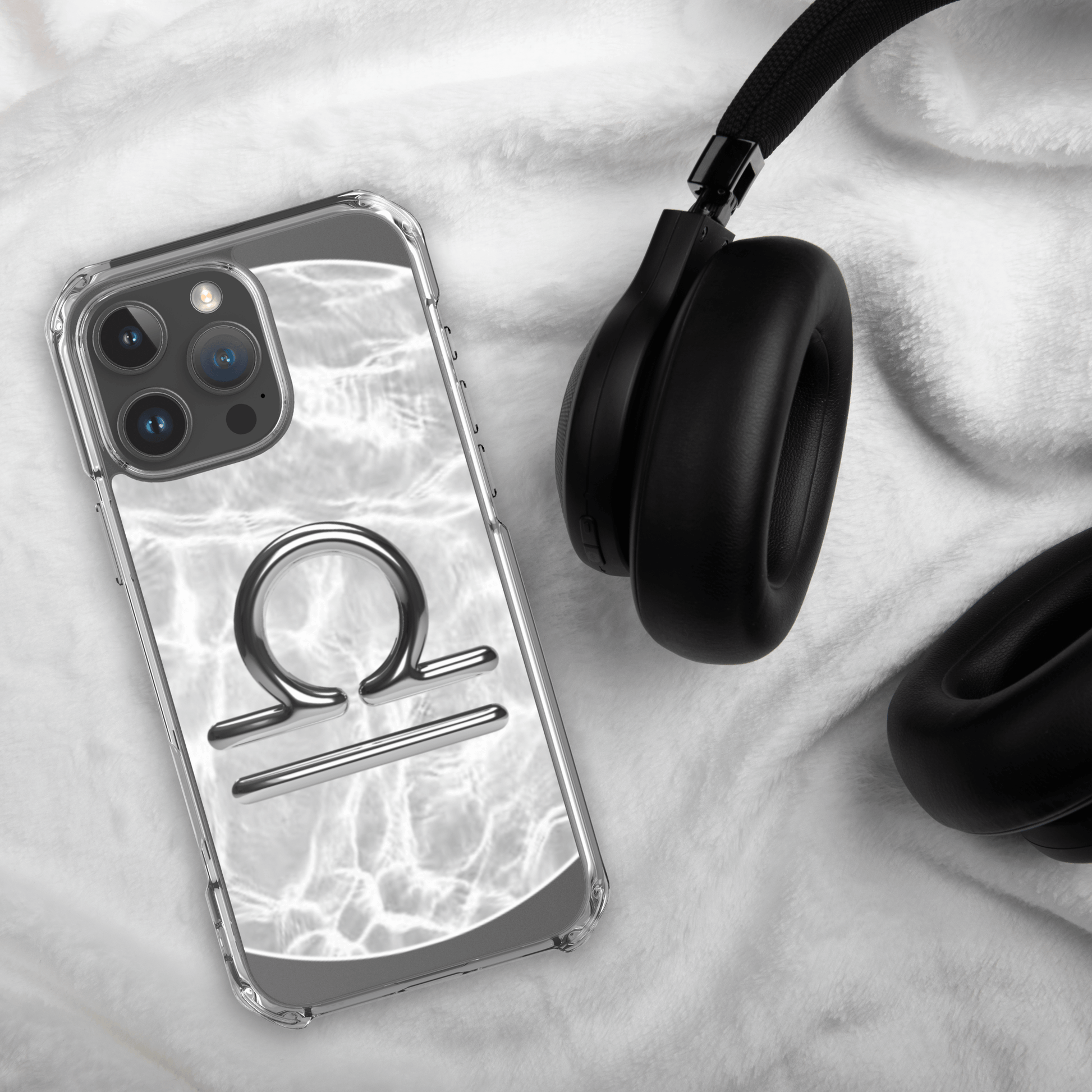 Libra zodiac Magsafe clear iPhone case with marble design next to headphones on soft background.