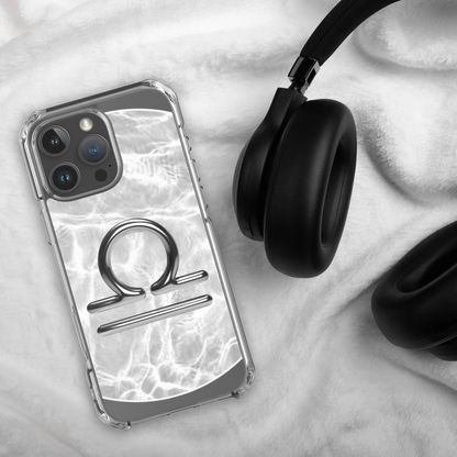 Libra zodiac Magsafe clear iPhone case with marble design next to headphones on soft background.