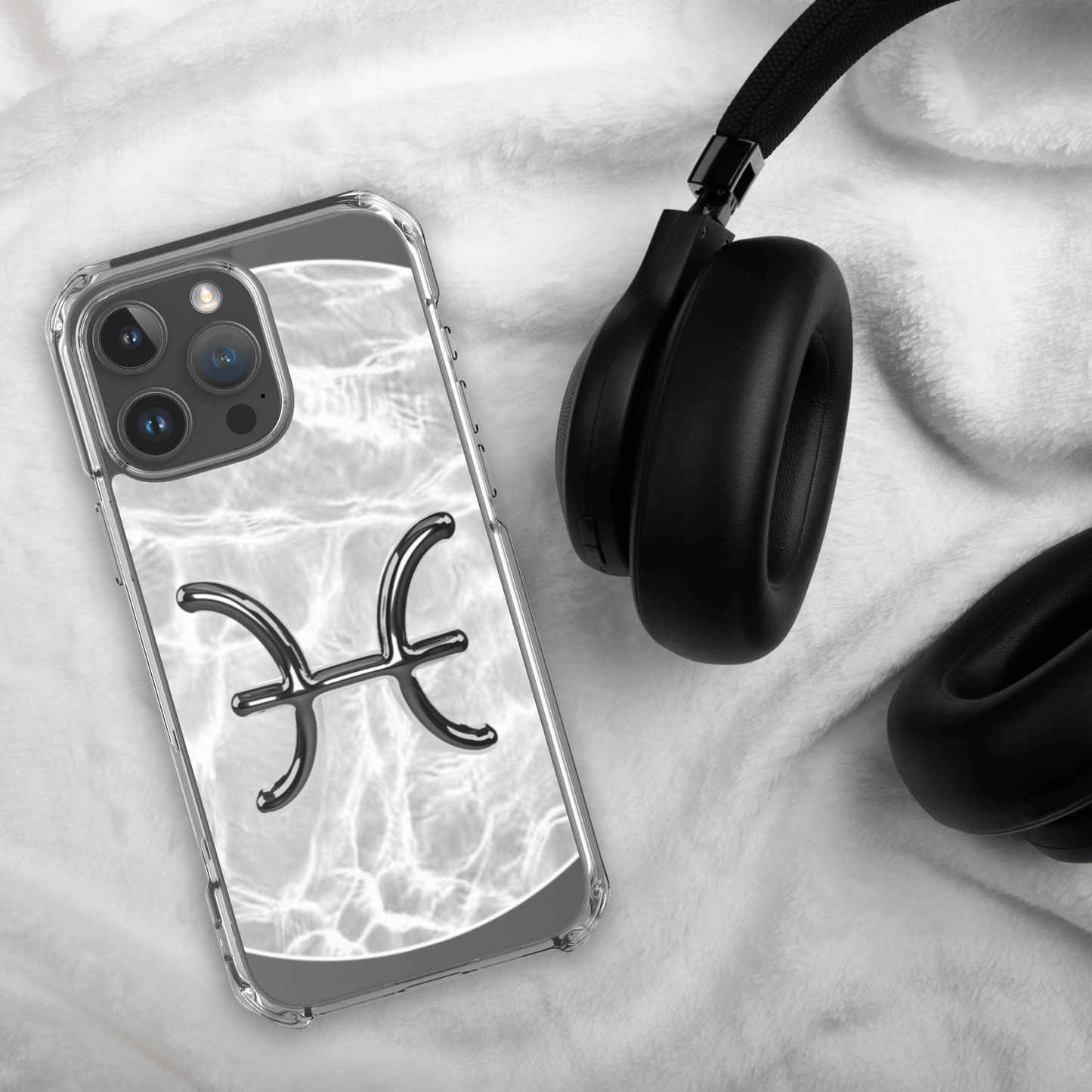 Zodiac Pisces Magsafe iPhone case with marble design on soft surface next to headphones.