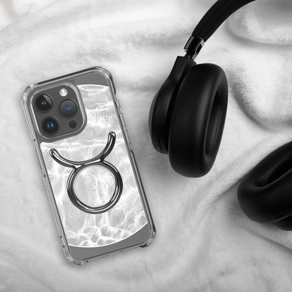 Zodiac Taurus MagSafe clear iPhone case with metallic design on marble background next to headphones.