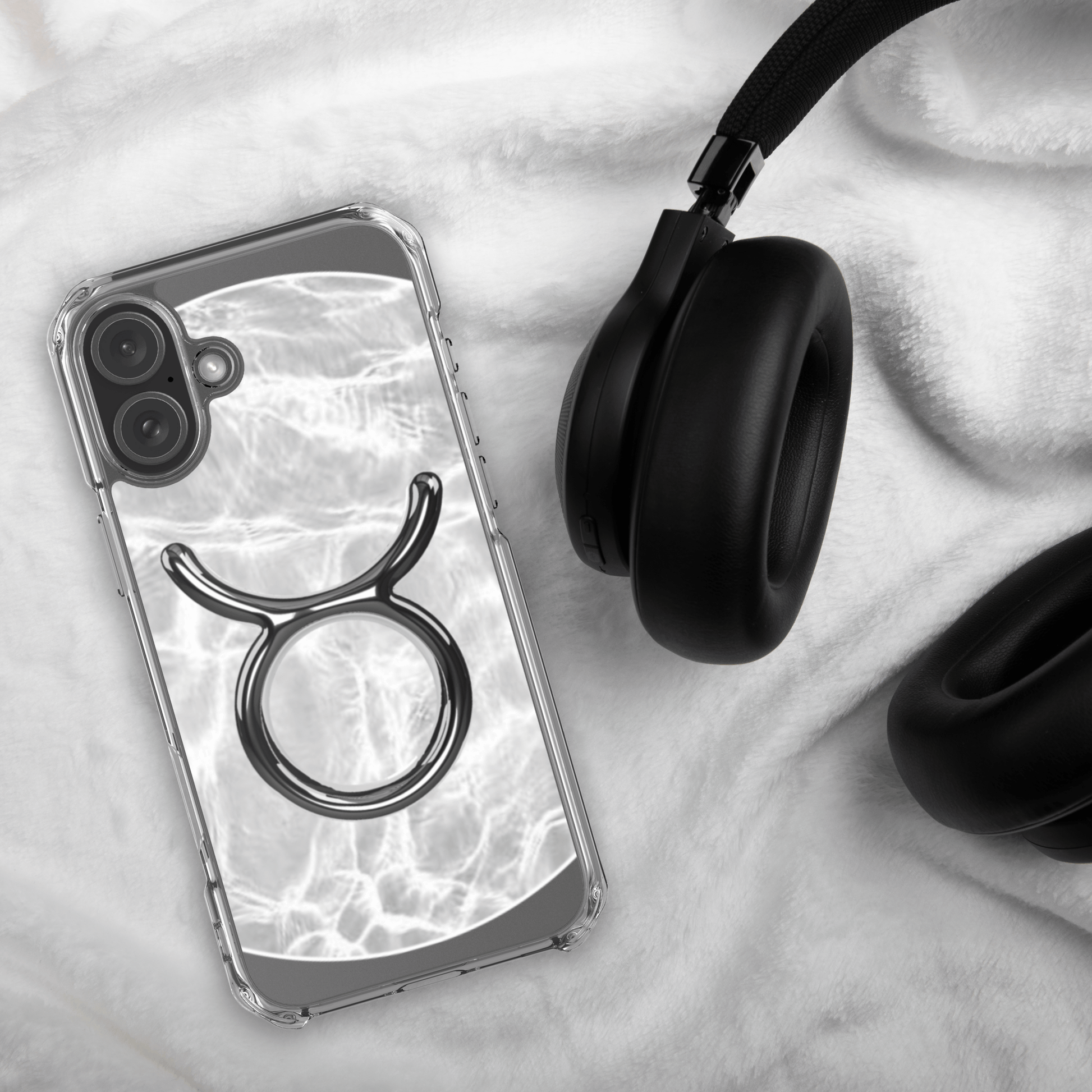 Zodiac Taurus Magsafe clear iPhone case with metallic design on marble background, styled with headphones.